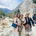Female pilgrims enjoying the beautiful Himalayan river on their Same Day Do Dham Yatra by helicopter Package.